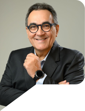 Diogenes dantas ao centro da imagem vestido de terno preto, ele sorri.